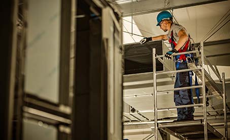 Person working on scaffolding inside building